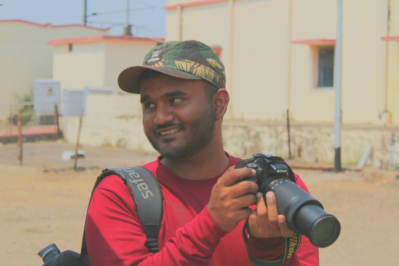 Profile photograph of Joel Mathew, a birdwatcher from Kerala with a camera in hand