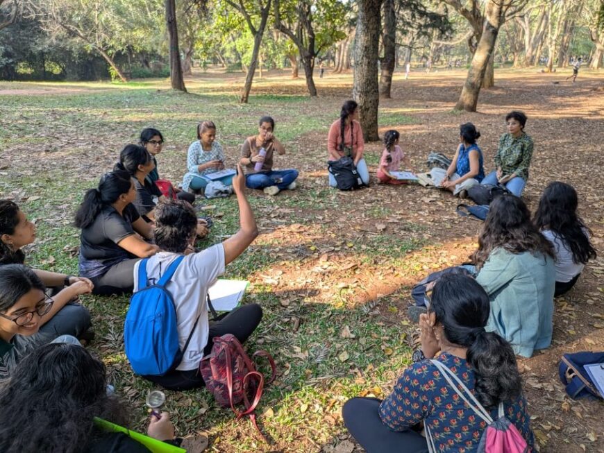 Photo from the All women nature walk, where particpants are sitting in a circle and discussion about the Sensory Exploration Activity that they participated in