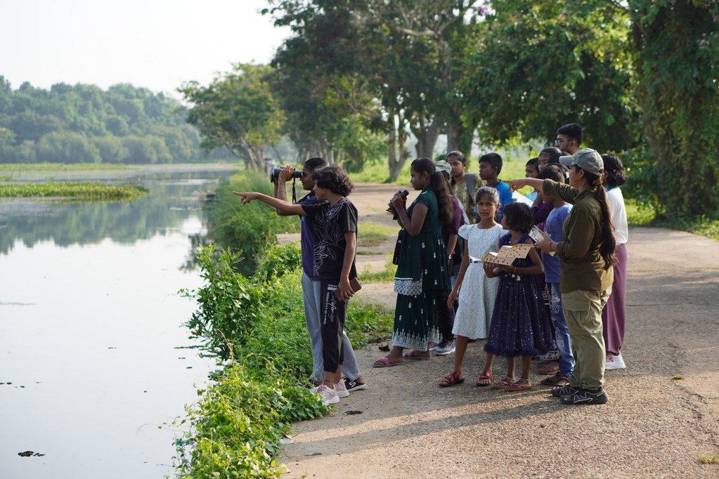 Children and young participants observing birds by a lakeside during the Rajo Bird Count 2025 at Nandankanan Zoological Park, Odisha.